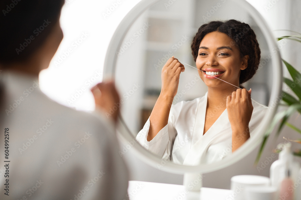 Oral Care. Smiling Black Woman Using Dental Floss Near Mirror At Home Oral Care. Smiling Black Woman Using Dental Floss Near Mirror At Home