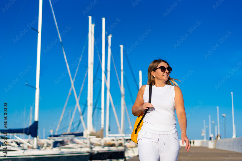 Beautiful woman on vacation walking in marina
