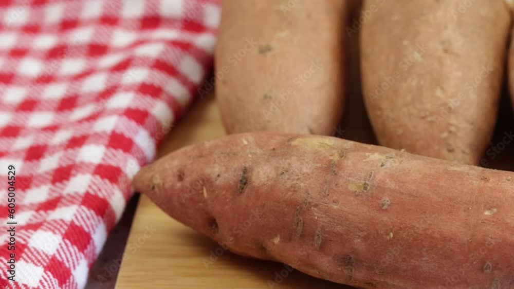 plusieurs patates douces crues, en gros plan, sur une table
