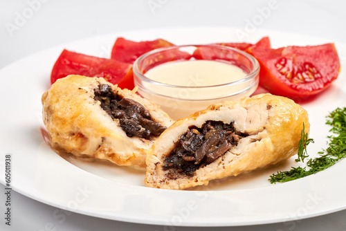 Chicken rolls with mushrooms served with fresh tomatoes, herbs and sauce