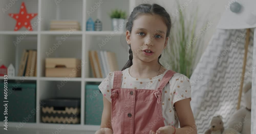 Portrait of joyful kid enjoying online video call talking waving hand sitting on floor at home. Communication and childhood concept. Portrait of joyful kid enjoying online video call talking waving hand sitting on floor at home. Communication and childhood concept.