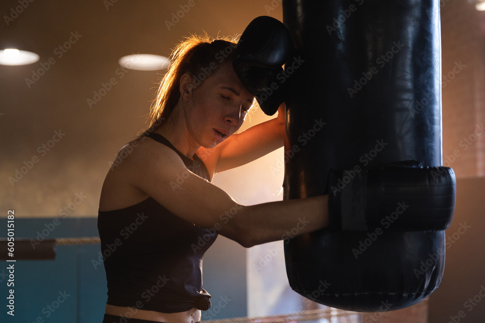 Women self defense girl power. Strong woman fighter resting after fight training on boxing ring. Strong girl tired after punching boxing bag. Training day in gym. Strength fit body workout training
