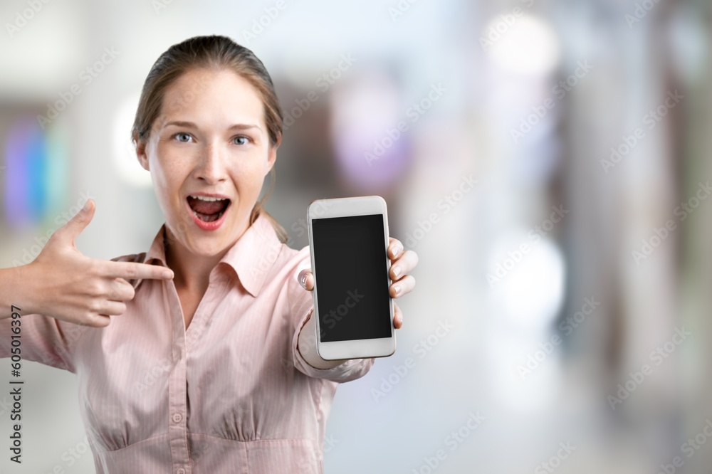 Laughing young woman holding a phone in hands Laughing young woman holding a phone in hands