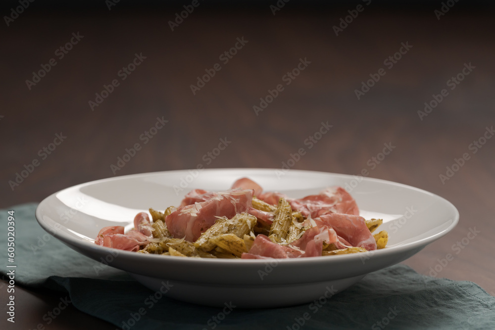 Penne pasta with capocollo, pesto and parmesan cheese