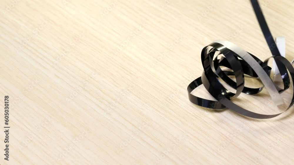Stop motion. Tape falling down into a jumbled heap. Curved lines like tangled threads
Stop motion. Tape falling down into a jumbled heap. Curved lines like tangled threads