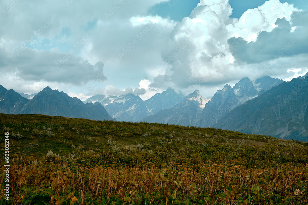 Fototapeta premium Mountain ranges on a sunny day at Georgia. Sky with clouds adn hills