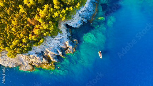 A sea bay. Clear turquoise water and a boat. View from the air. Summer landscape from a drone. Rest and travel in the summer time. The season for vacation. Photography for design.