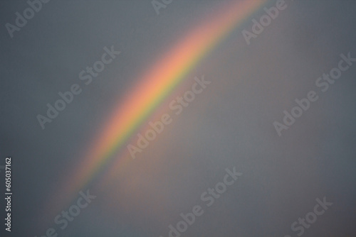 Rainbow in the sky. After the rain, a rainbow appears. 7 colors of the rainbow. Overcast sky. Beautiful sky on a summer evening.