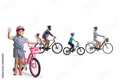 Family riding bicycles and a girl waving at camera
