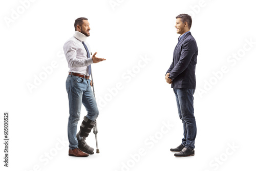 Full length profile shot of an injured man with a walking brace and cervical collar talking to a friend