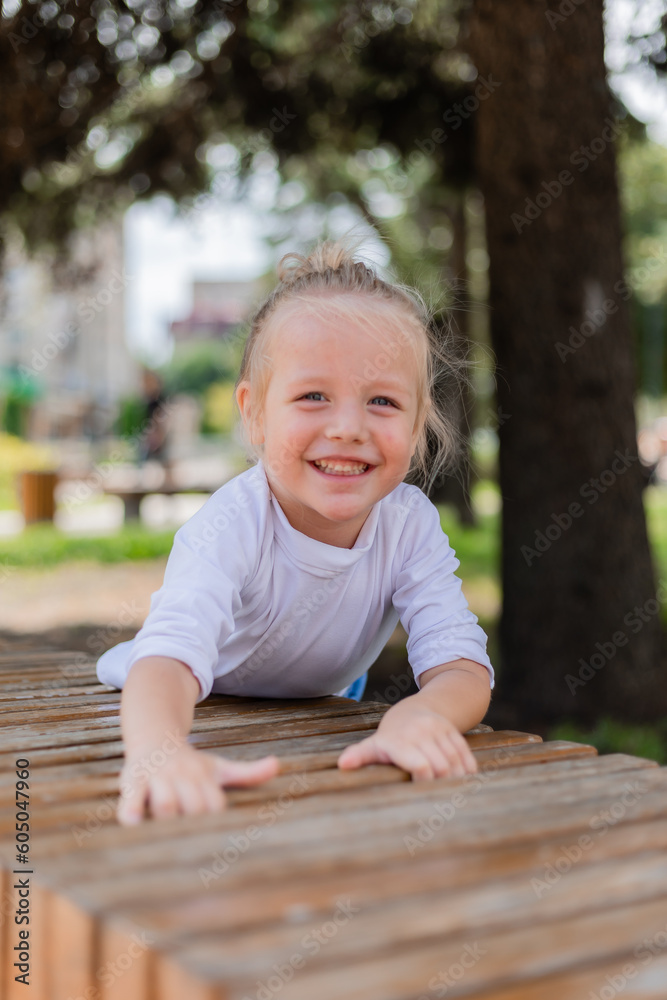 happy little blond boy playing in a children's town on a summer day happy little blond boy playing in a children's town on a summer day