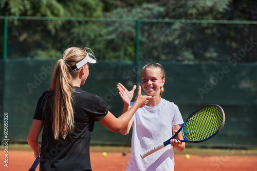 Two female tennis players shaking hands with smiles on a sunny day, exuding sportsmanship and friendship after a competitive match. © .shock