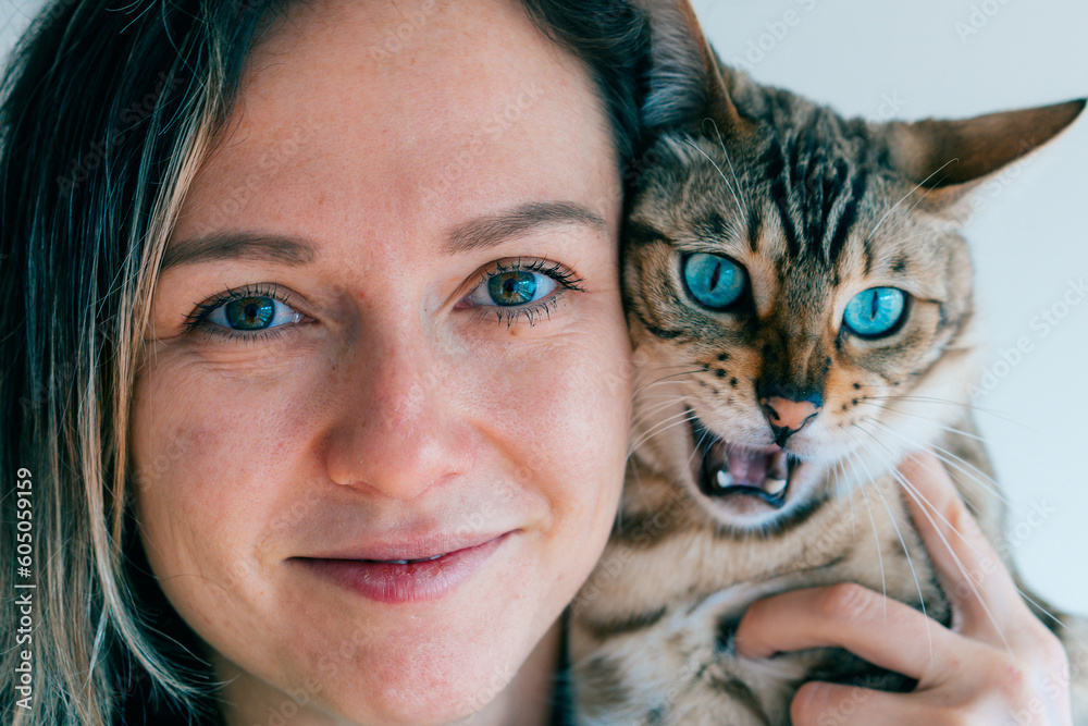portrait of a girl and her bengal cat. Blue eyes