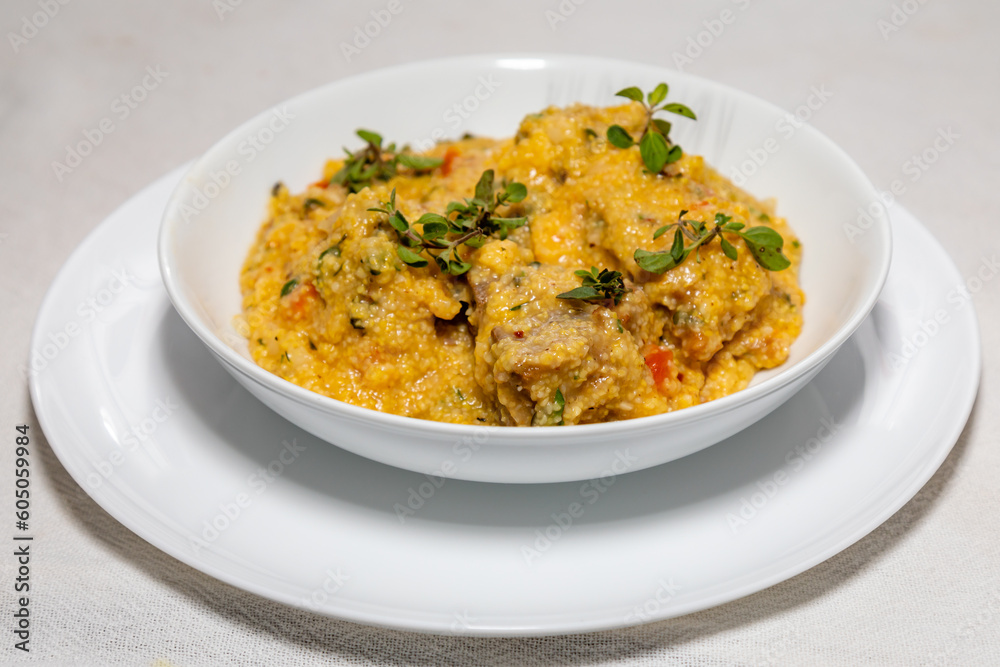Traditional pork tenderloin recipe with corn grits and fresh marjoram (Origanum majorana). Traditional pork tenderloin recipe with corn grits and fresh marjoram (Origanum majorana).