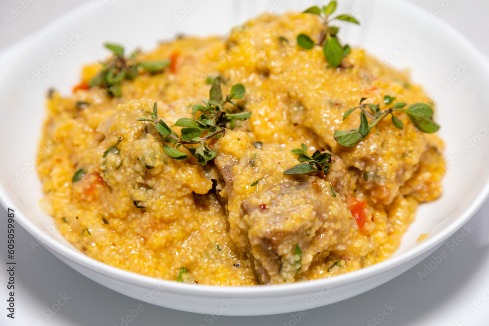Traditional pork tenderloin recipe with corn grits and fresh marjoram (Origanum majorana). Traditional pork tenderloin recipe with corn grits and fresh marjoram (Origanum majorana).