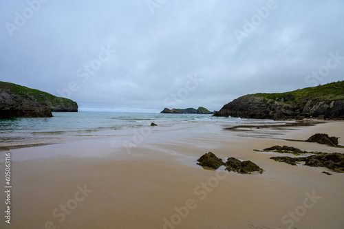 View on Playa de Borizo in Celorio, Green coast of Asturias, North Spain with sandy beaches, cliffs, hidden caves, green fields and mountains. © barmalini