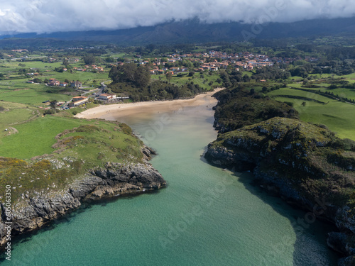 Aerial view on Playa de Poo during low tide near Llanes, Green coast of  Asturias, North Spain with sandy beaches, cliffs, hidden caves, green  fields and mountains. Photos | Adobe Stock