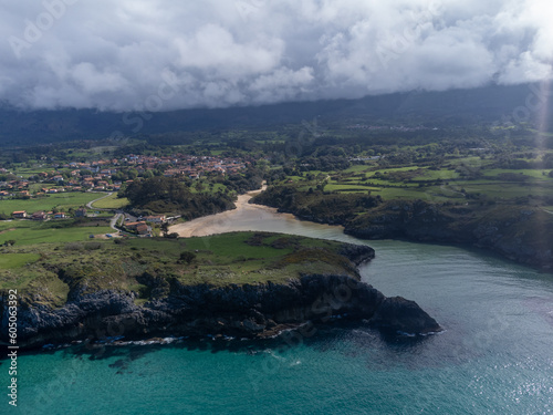 Aerial view on Playa de Poo during low tide near Llanes, Green coast of Asturias, North Spain with sandy beaches, cliffs, hidden caves, green fields and mountains. photo