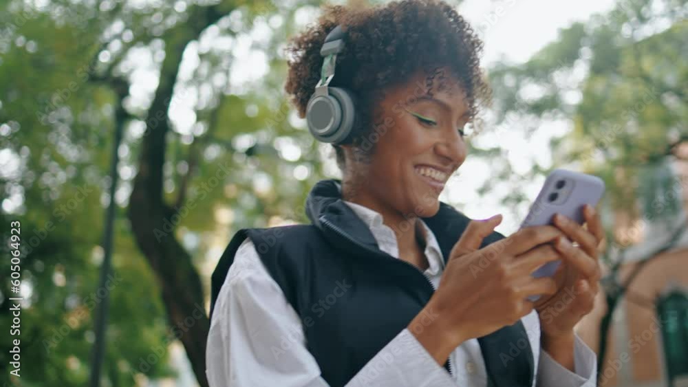 Woman turning on music at wireless earphones standing city street close up. Woman turning on music at wireless earphones standing city street close up.