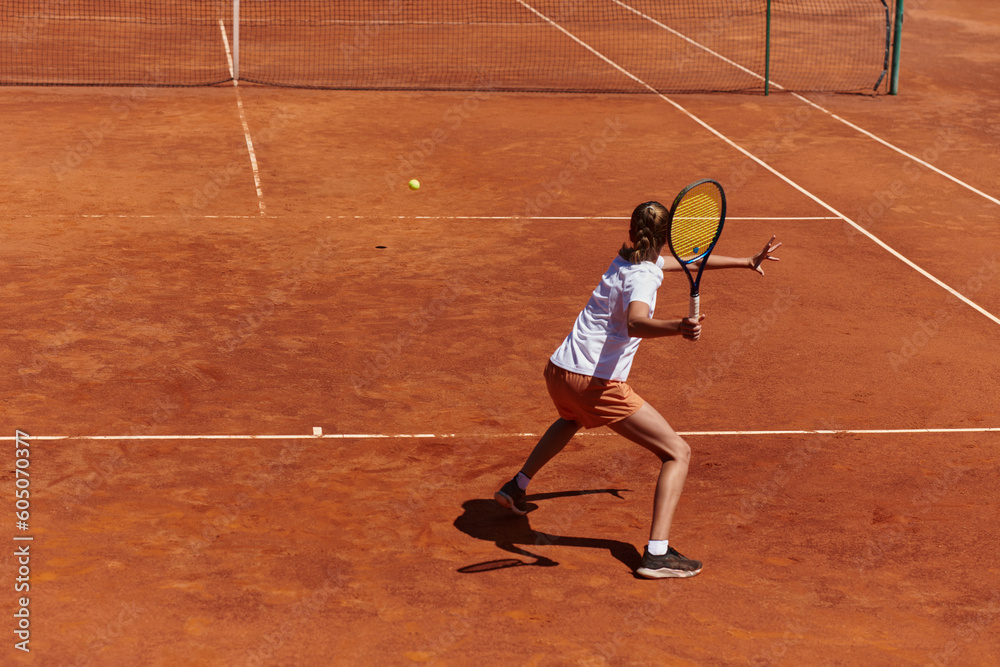 A young girl showing professional tennis skills in a competitive match on a sunny day, surrounded by the modern aesthetics of a tennis court.