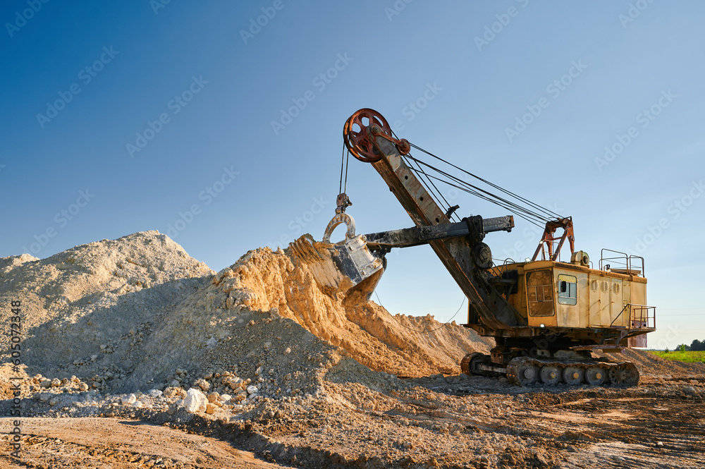 Shovel mining excavator operates in large open chalk quarry - obrazy, fototapety, plakaty 