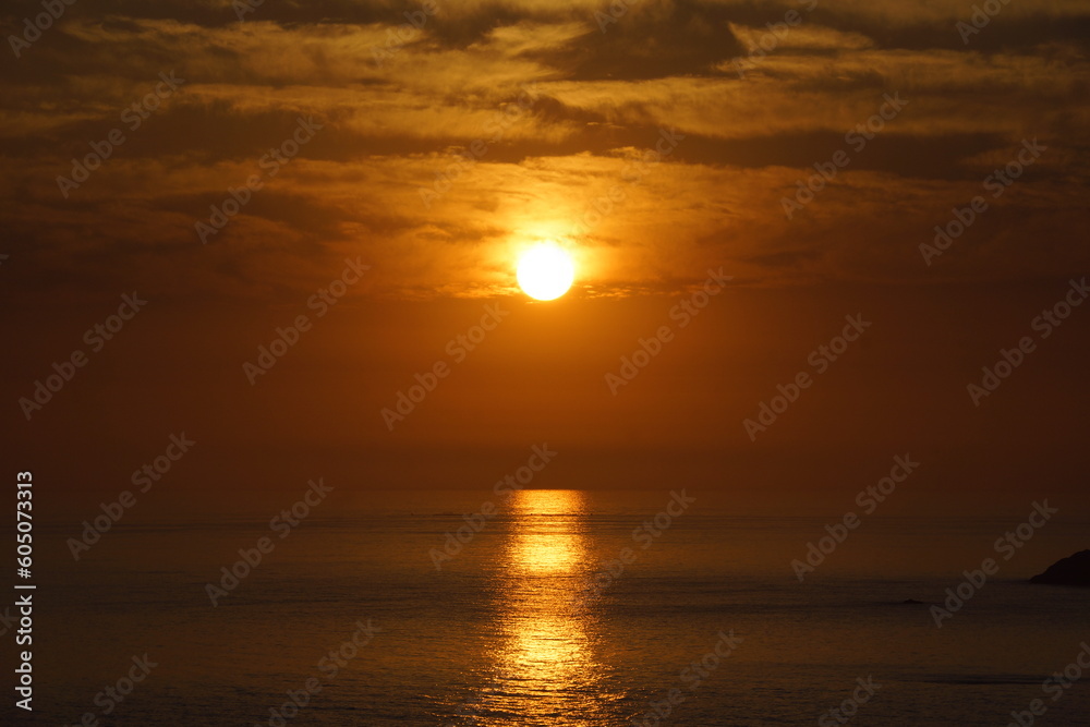 Sol resplandeciendo sobre el mar durante el atardecer