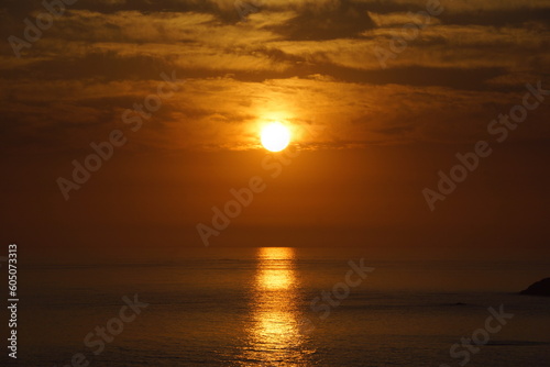 Sol resplandeciendo sobre el mar durante el atardecer