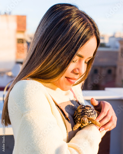 pretty latin woman with a tortoise pet