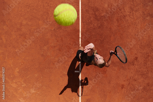 Top view of a professional female tennis player serves the tennis ball on the court with precision and power © .shock