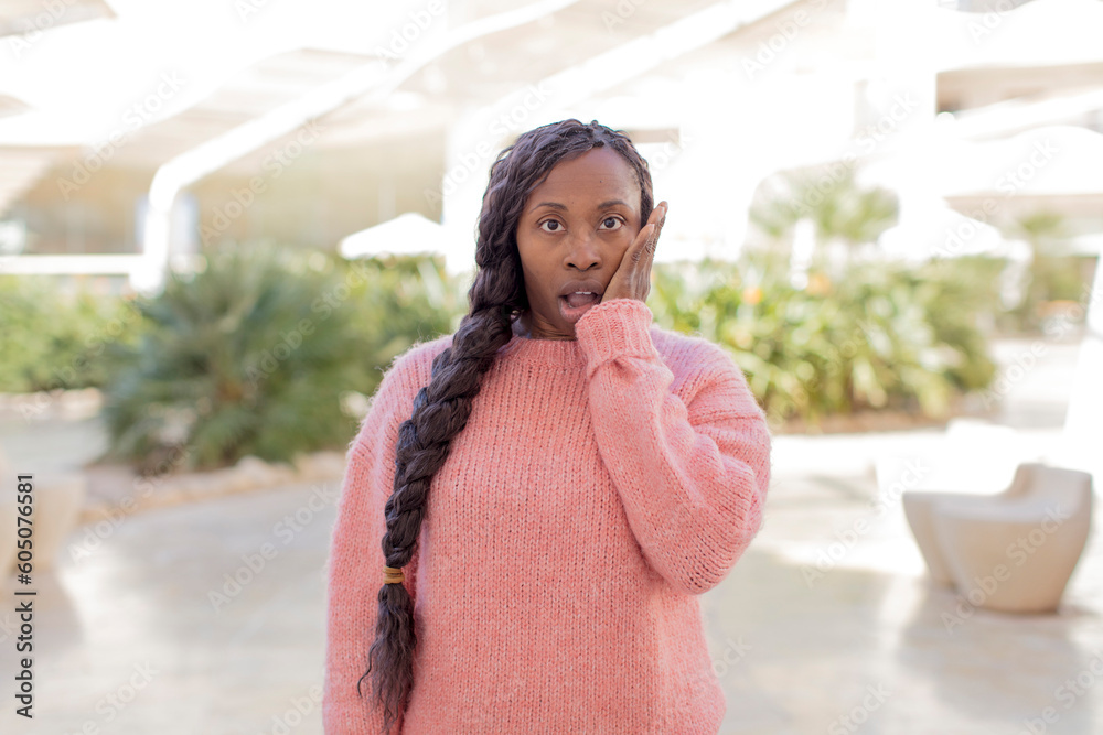afro pretty black woman feeling shocked and astonished holding face to hand in disbelief with mouth wide open afro pretty black woman feeling shocked and astonished holding face to hand in disbelief with mouth wide open
