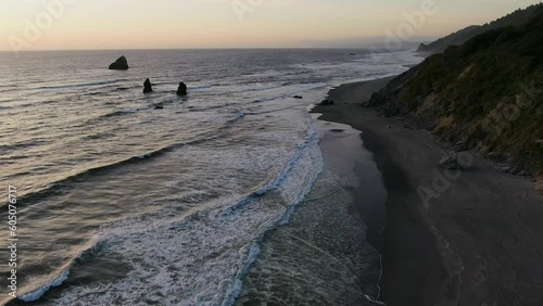 Aerial cinematic drone coastline Northern California at Eureka Humboldt county during pink sunset haystacks on highway 101 Redwoods forest lagoon ocean surf waves to forward motion photo