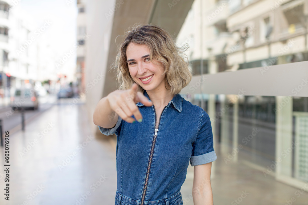 Fototapeta premium pretty woman pointing at camera with a satisfied, confident, friendly smile, choosing you