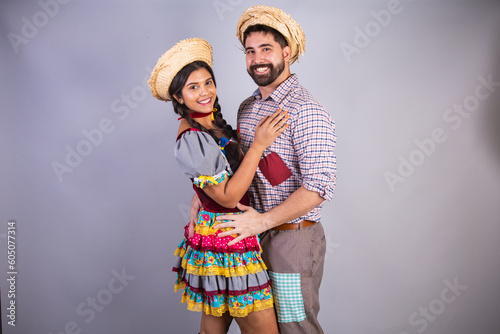 brazilian couple, clothes from festa junina, arraial, festa de são joão. boyfriend and girlfriend, kissing booth. love. Embraced.