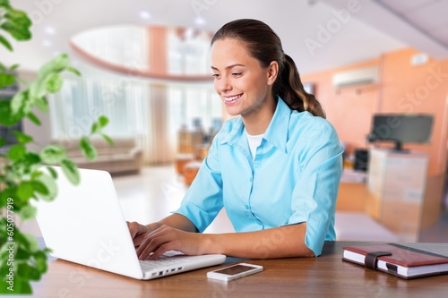 Happy woman works on laptop in home office