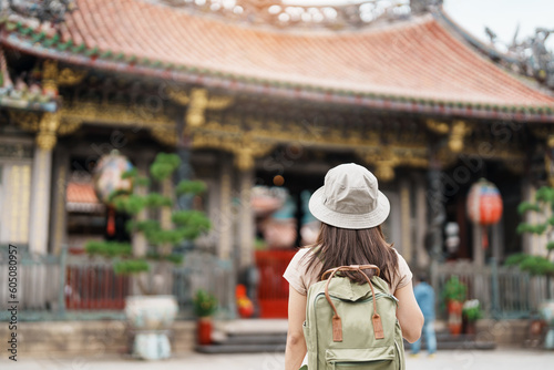 woman traveler visiting in Taiwan, Tourist with hat sightseeing in Longshan Temple, Chinese folk religious temple in Wanhua District, Taipei City. landmark and popular. Travel and Vacation concept