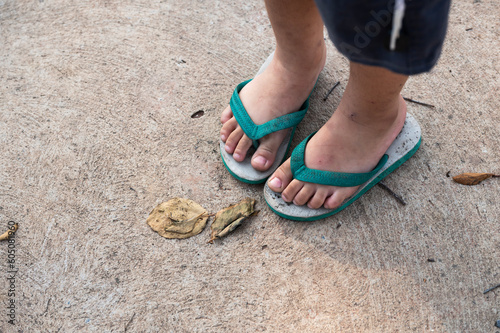 Children's old shoes sandal standing on old cement texture background.