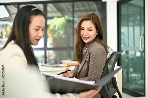 Professional Asian businesswoman giving advice and sharing her ideas on her colleague's work Free Download Professional Asian businesswoman giving advice and sharing her ideas on her colleague's work - GFXLoad