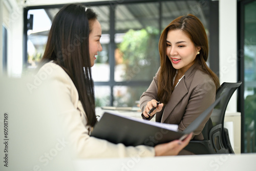Professional businesswoman sharing her ideas on her colleague's work in the office.