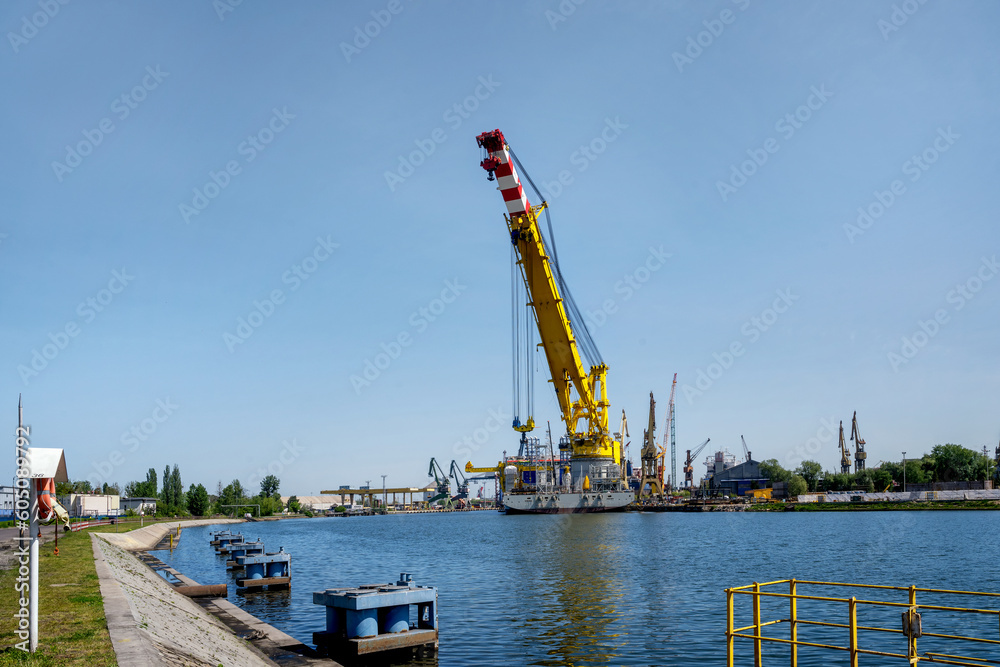 The world's largest ship, a crane for erecting windmills at sea, displacement 61,000, lifting capacity 5,000 tons, moored at the quay of Stocznia Remontowa, Gdansk, Poland - Les Alizés (IMO number 991 - obrazy, fototapety, plakaty 