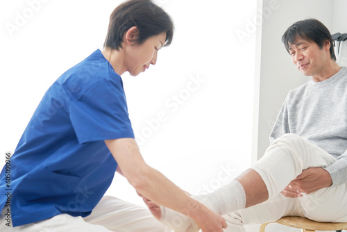 足首に包帯を巻く看護師