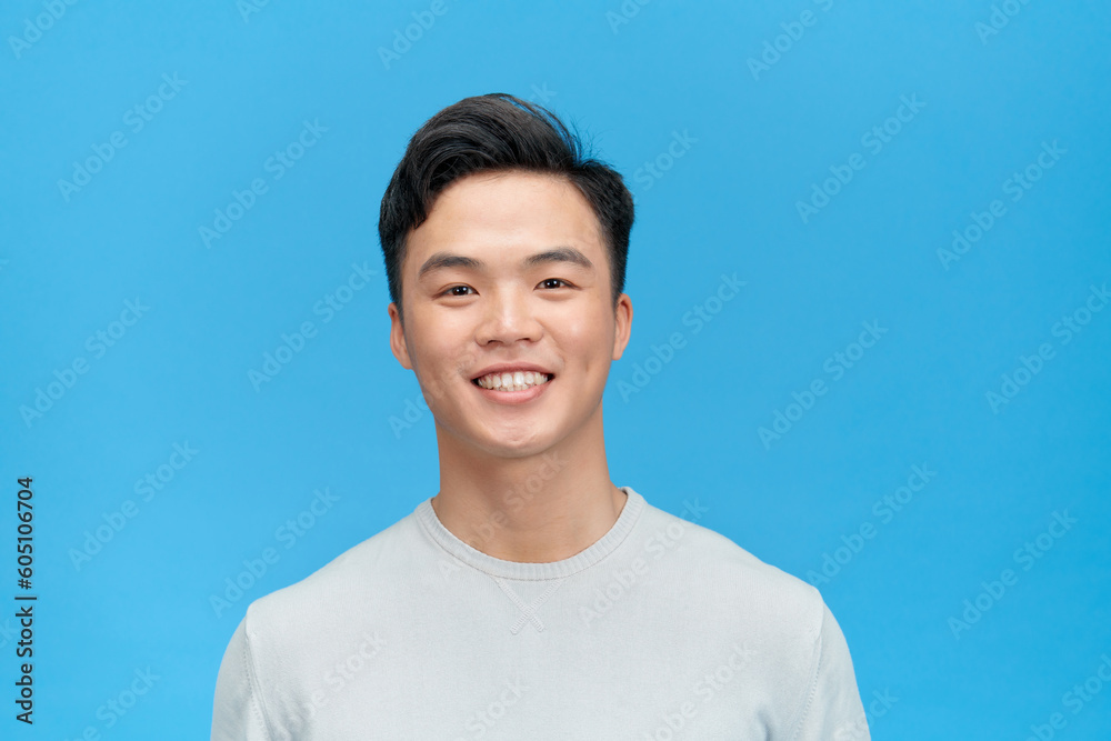 portrait of young smiling handsome guy isolated on blue background portrait of young smiling handsome guy isolated on blue background
