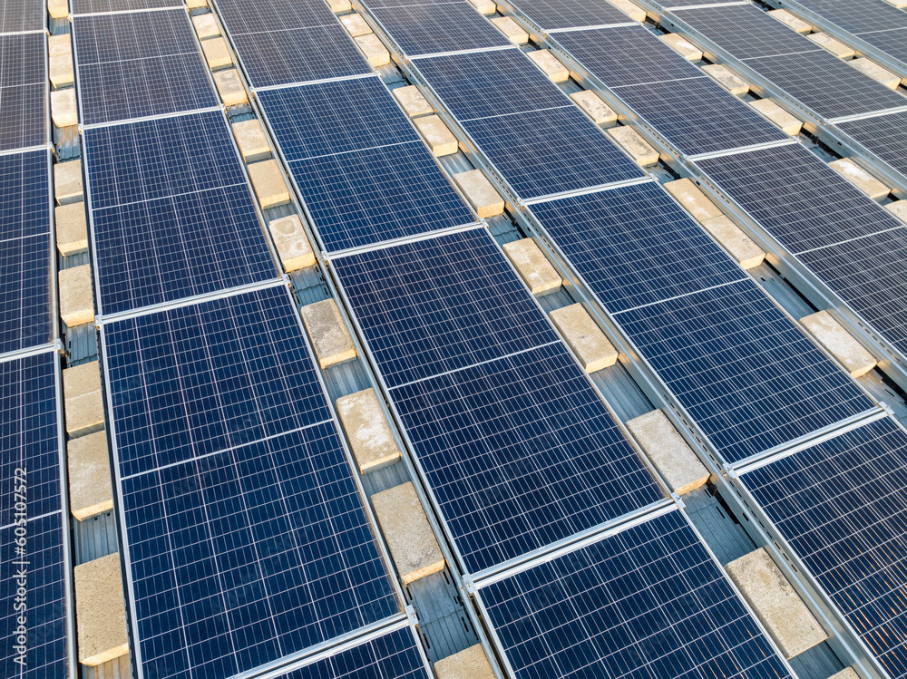 Aerial photo solar panels install on a flat commercial, industrial roof, with concrete blocks.
Aerial photo solar panels install on a flat commercial, industrial roof, with concrete blocks.