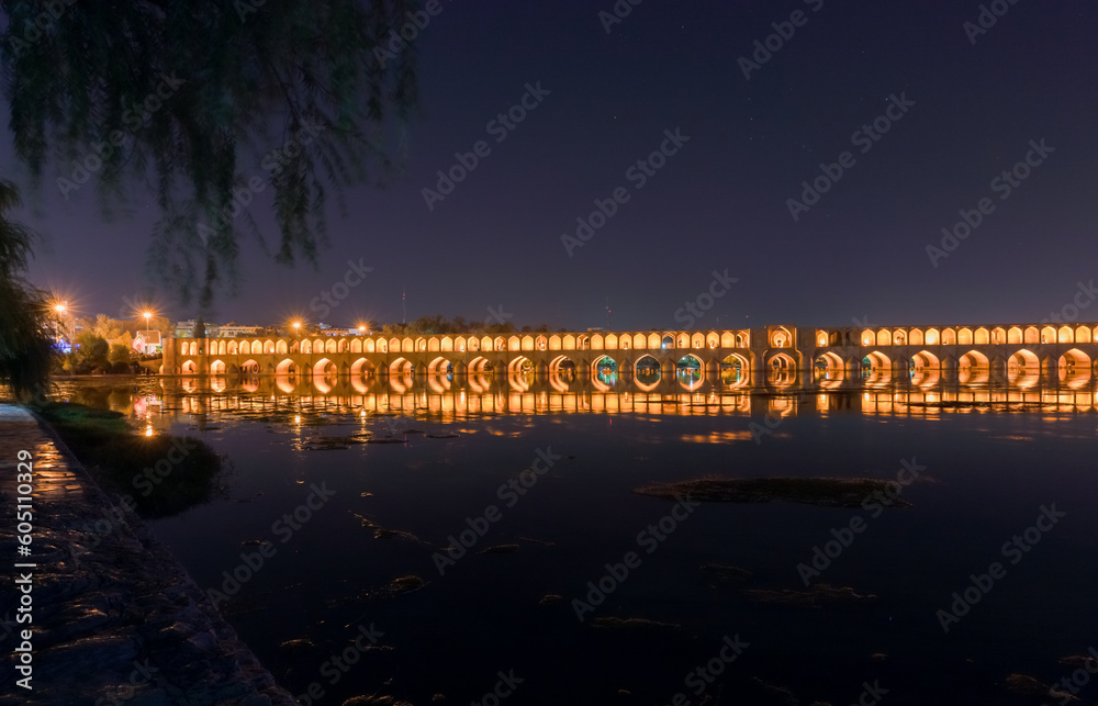 Si-o-Se Pol (Bridge of 33 Arches or Allahverdi Khan Bridge) at night on Zayanderud River in Isfahan, Iran. Architectural masterpiece and historical heritage. Tourist destination.