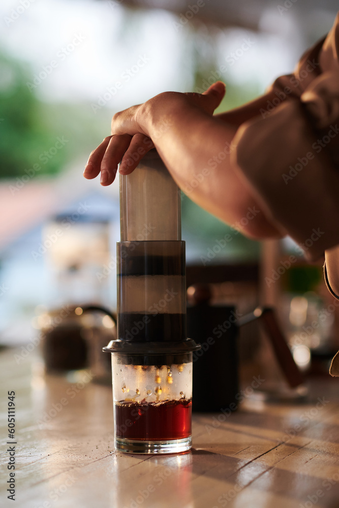 Barista using aeropress when making cup of coffee for customer Barista using aeropress when making cup of coffee for customer