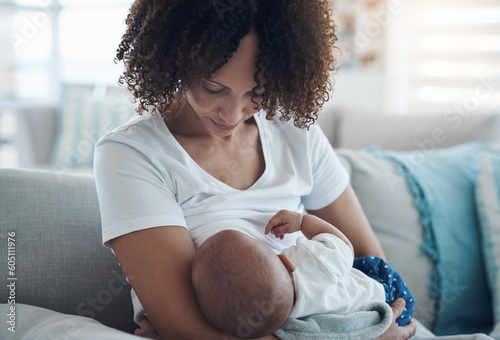 Love, living room and mother breastfeeding her baby for health, nutrition and wellness at home. Bonding, care and young woman nursing or feeding her newborn child milk on the sofa in the family house photo