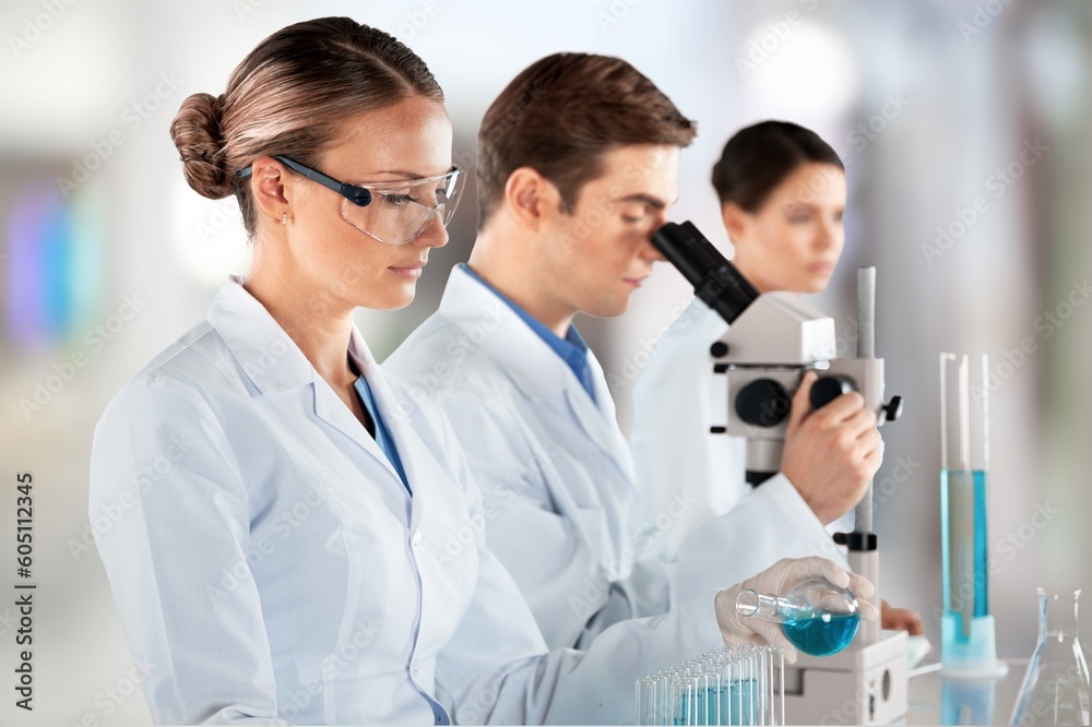 Young researcher with samples and microscope in lab Young researcher with samples and microscope in lab