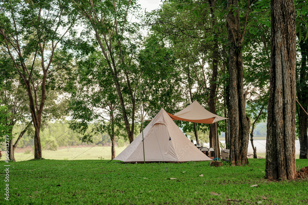Setting up a camping tent in the midst of green nature garden. Selection focus on camping tent