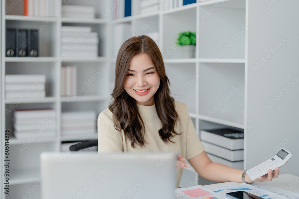 Beautiful young teen asian businesswoman using computer laptop and calculator for calculate with planning working on financial document, tax, exchange, accounting and Financial advisor Beautiful young teen asian businesswoman using computer laptop and calculator for calculate with planning working on financial document, tax, exchange, accounting and Financial advisor