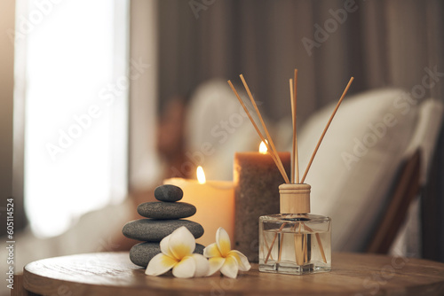 Spa, aromatherapy and candles on table for zen, calm and peace to relax for health and wellness. Stones, flowers and diffuser for self care, holistic massage and hospitality at a beauty salon