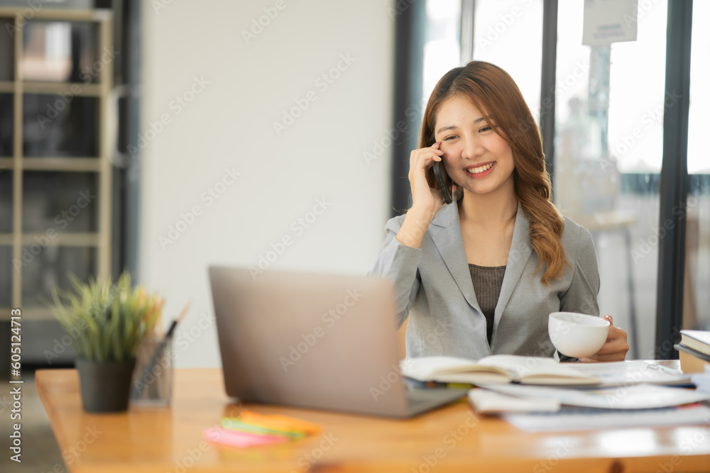 Asian businesswoman holding notebook about business, spending money Asian businesswoman holding notebook about business, spending money